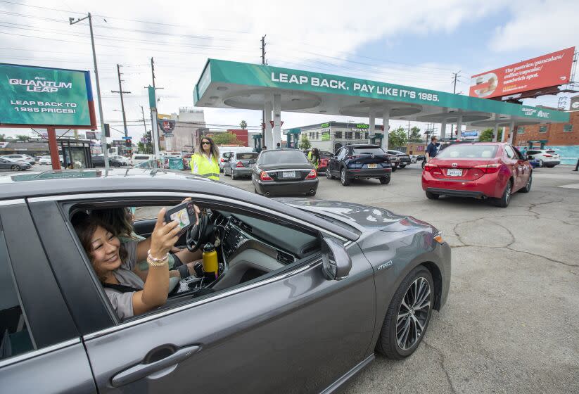 LOS ANGELES, CA-SEPTEMBER 15, 2022: Jenny Wanland of Glendora takes a selfie as her daughter Brianna Minton pulls into a pop up gas station at the intersection of Vine St. and Santa Monica Blvd. in Los Angeles. Inspired by the new series Quantum Leap, premiering on September 19, 2022, NBC offered consumers the opportunity to pay prices based on the year of the premiere episode in 1985. Each car could get a maximum of 10 gallons of gas. (Mel Melcon/Los Angeles Times)