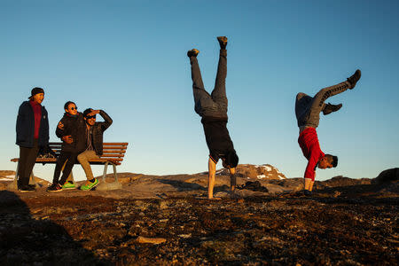 Young native Greenlanders take advantage of the last rays of daylight on a hill above the town of Tasiilaq, Greenland, June 18, 2018. REUTERS/Lucas Jackson