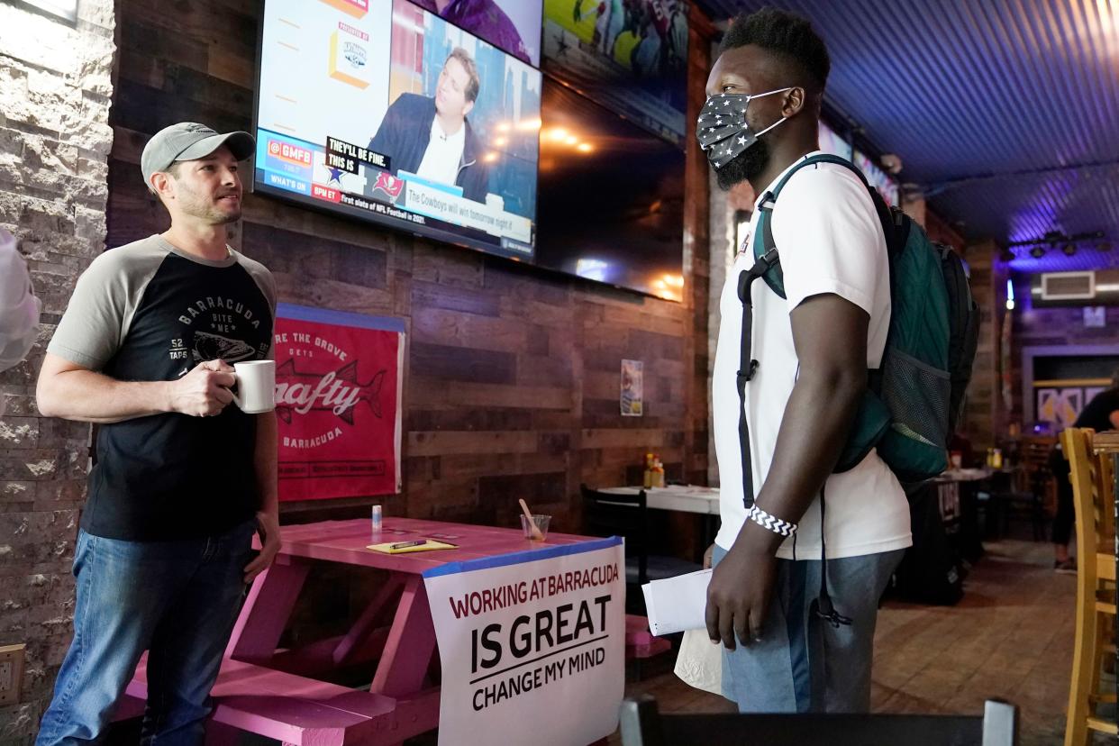 Sudy Gervais, right, talks with Lee Kessler, the owner of the Barracuda Taphouse & Grill, left, about a potential job at a job fair featuring local businesses in the Coconut Grove neighborhood of Miami, Florida.