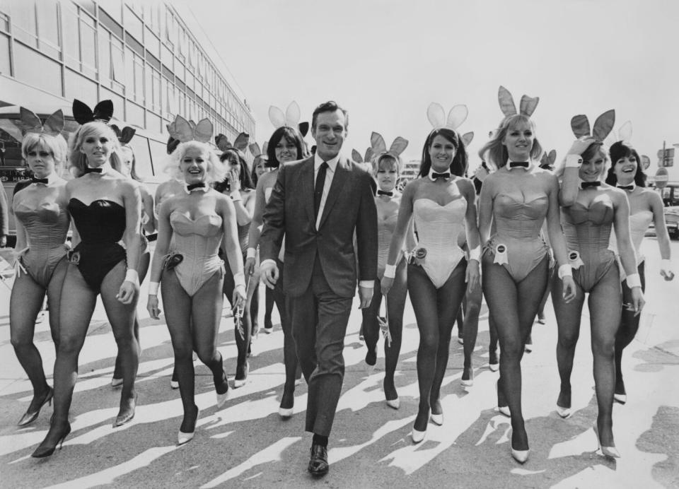 A man in a suit is surrounded by dozens of women wearing bunny costumes