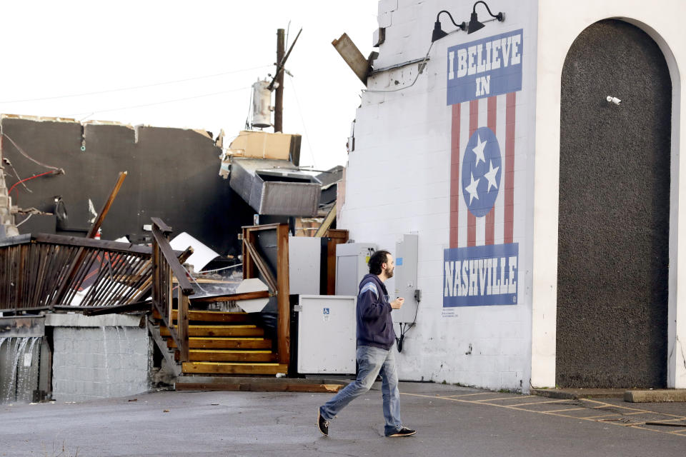 A man walks by The Basement East, a live music venue destroyed by storms Tuesday, March 3, 2020, in Nashville, Tenn. Tornadoes ripped across Tennessee early Tuesday, shredding buildings and killing multiple people. (AP Photo/Mark Humphrey)