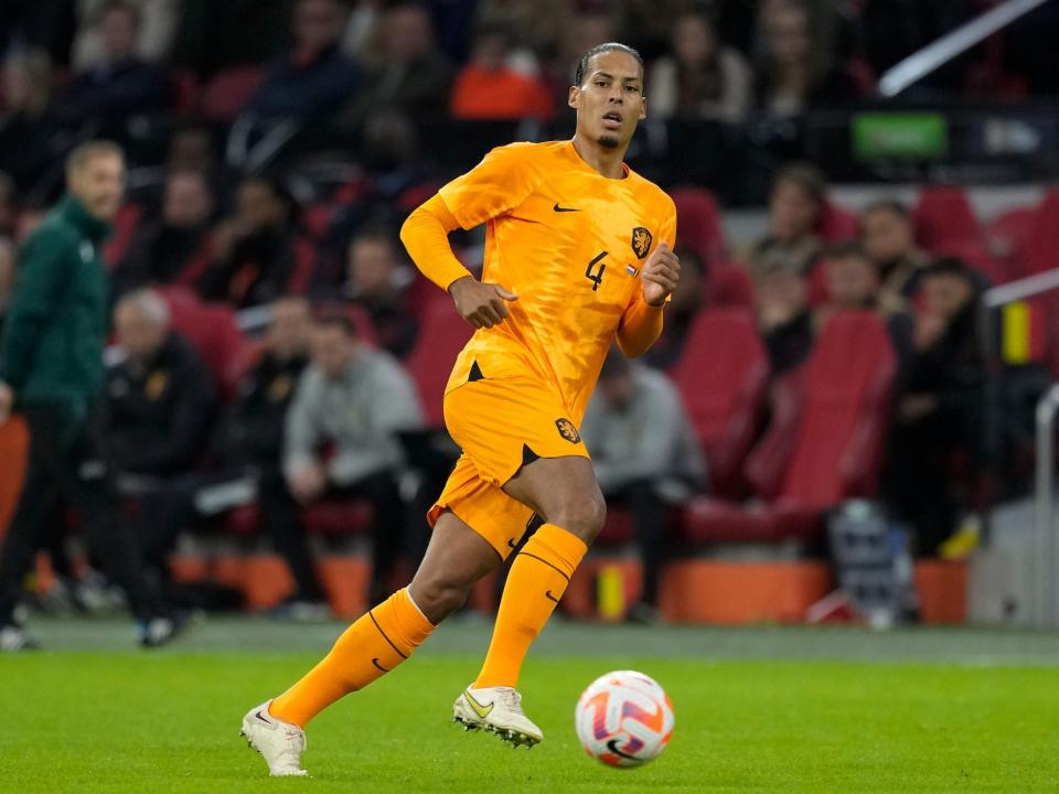 Virgil van Dijk dribbles the ball and looks on during a Netherlands soccer match.