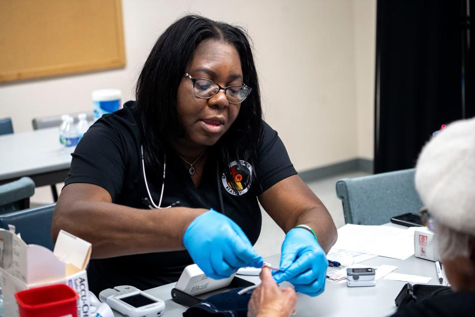 Angela Mickens checks the blood sugar of a patient during a Black Women’s Health Coalition event by Black Women 4 Healthy Living at Corinthian Baptist Church on Saturday, November 18, 2023 in Des Moines.