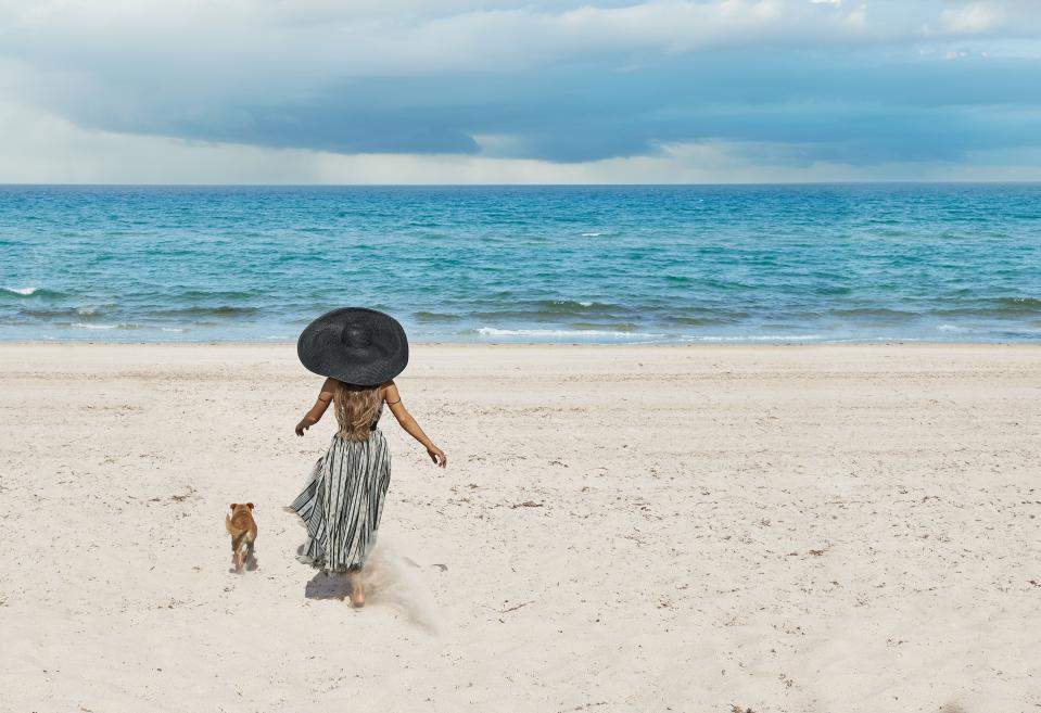 No Place Like Home
With her dog Toulouse at a local beach in Boca Raton. Dior dress. Eric Javits hat.
In this story: hair for Ariana Grande by Josh Liu, hair for Joan and Marjorie Grande by Cedric Salon; makeup for Ariana Grande by Hannah Murray, makeup for Joan and Marjorie Grande by Edward Cruz.