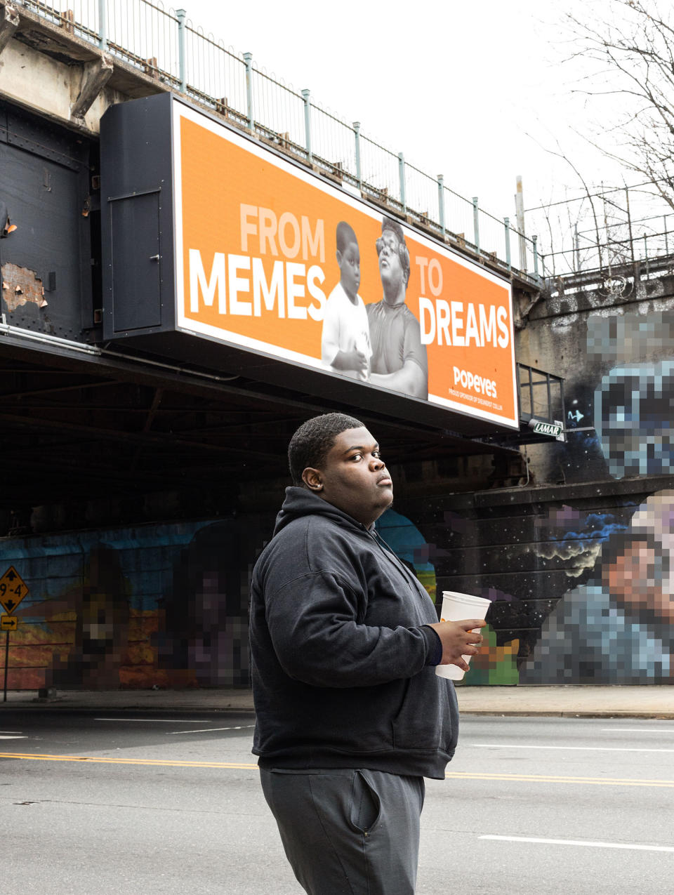 Dieunerst Collin with his Popeyes billboard. (Courtesy Popeyes)