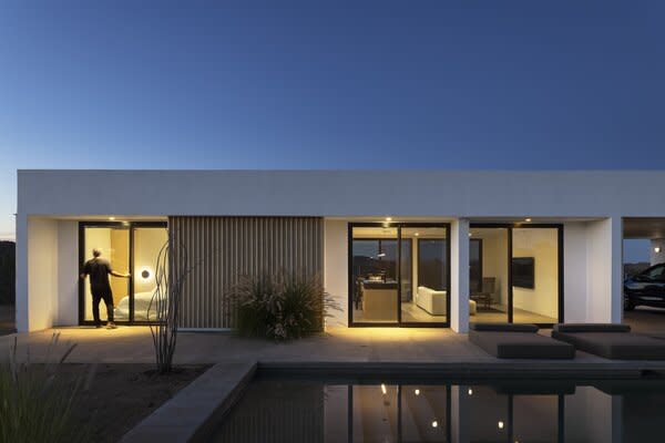 The house was conceived as a kind of umbrella, providing shelter for a series of bedrooms and the great room below, as well as an adjacent carport that doubles as covered outdoor space.