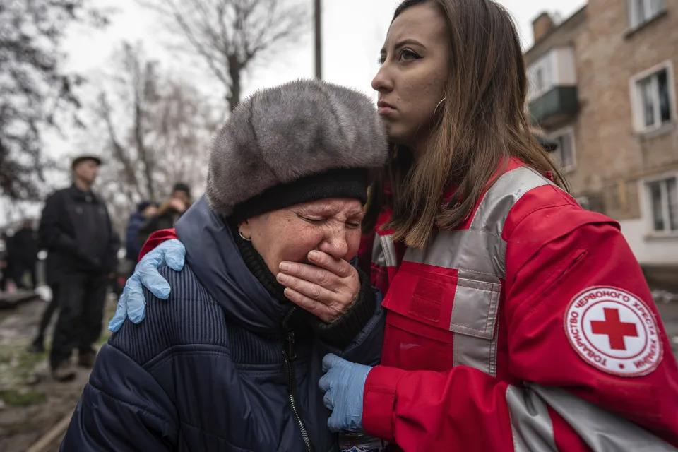 A woman cries in front of the building which was destroyed by a Russian attack in Kryvyi Rih, Ukraine, Friday, Dec. 16, 2022. Russian forces launched at least 60 missiles across Ukraine on Friday, officials said, reporting explosions in at least four cities, including Kyiv. At least two people were killed by a strike on a residential building in central Ukraine, where a hunt was on for survivors. (AP Photo/Evgeniy Maloletka)