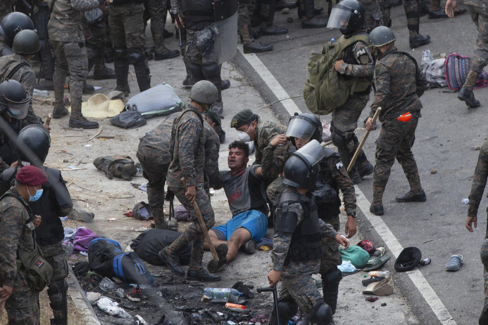 A Honduran migrant is tended to by Guatemalan soldiers after they clashed with them in a bid to reach the U.S. border in Vado Hondo, Guatemala, Sunday, Jan. 17, 2021. Guatemalan authorities estimated that as many as 9,000 Honduran migrants crossed into Guatemala as part of an effort to form a new caravan to reach the U.S. border. (AP Photo/Sandra Sebastian)