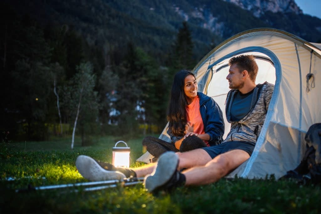 A couple camp in a park.