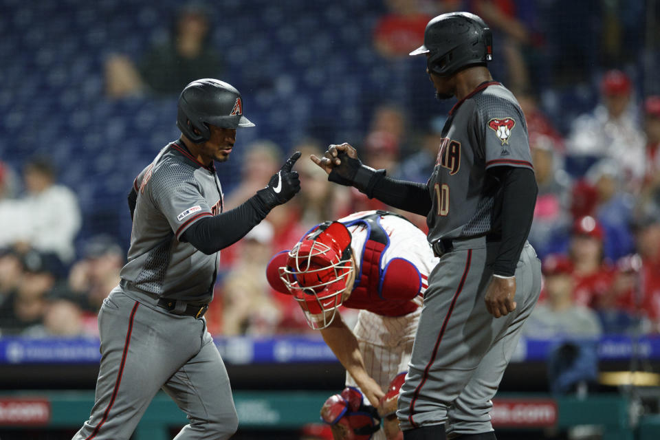 Arizona Diamondbacks' Eduardo Escobar, left, and Adam Jones, right, celebrate past Philadelphia Phillies catcher J.T. Realmuto after Escobar's two-run home run off starting pitcher Jerad Eickhoff during the fourth inning of a baseball game, Monday, June 10, 2019, in Philadelphia. (AP Photo/Matt Slocum)