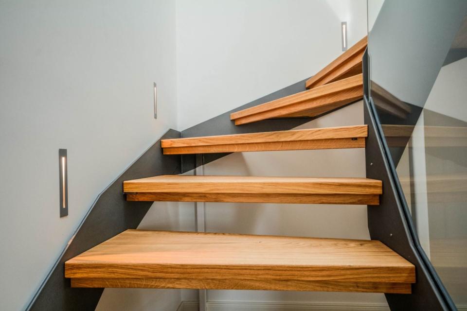 Glass railing lines wooden stairs. 