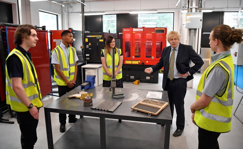 Britain's Prime Minister Boris Johnson gestures as he speaks with construction apprentices at The Dudley Institute of Technology in Dudley