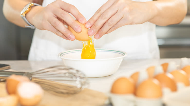 Person cracking egg into bowl