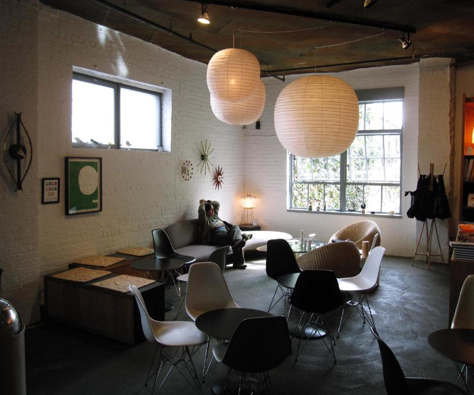 This April 20, 2013 photo shows a visitor relaxing in the cafe and gift shop at the Noguchi Museum in Long Island City, N.Y. The area is decorated with the lighting sculptures designed by the late Isamu Noguchi. The lamps, which became widely imitated classics of mid-20th century modern home design, are also sold in the gift shop. (AP Photo/Beth J. Harpaz)