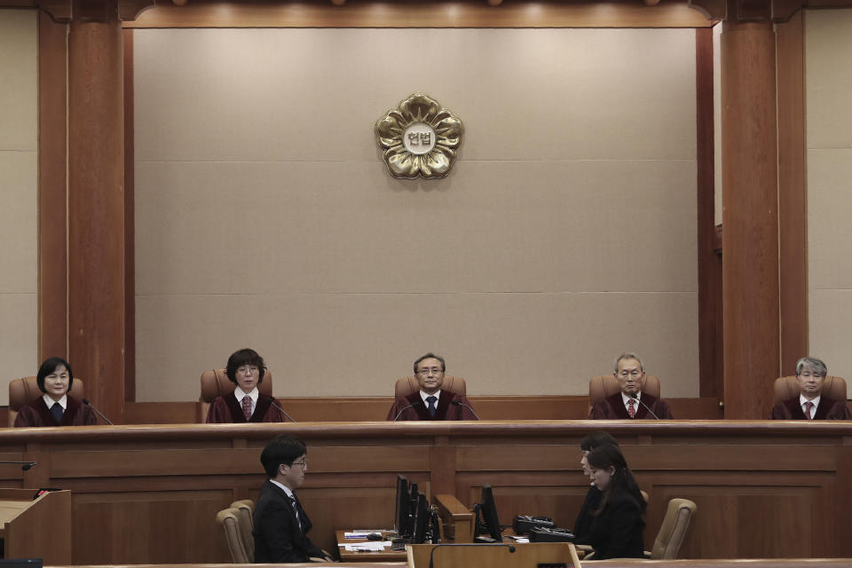 South Korea's Constitutional Court Chief Justice Yoo Nam-seok, top center, and other judges sit before the judgment at the Constitutional Court in Seoul, South Korea, Friday, Dec. 27, 2019. South Korea's Constitutional Court on Friday turned down an attempt to repeal a contentious 2015 deal with Japan to settle bitter disputes over Korean women enslaved for sex by the Japanese military during the World War II.(AP Photo/Ahn Young-joon)