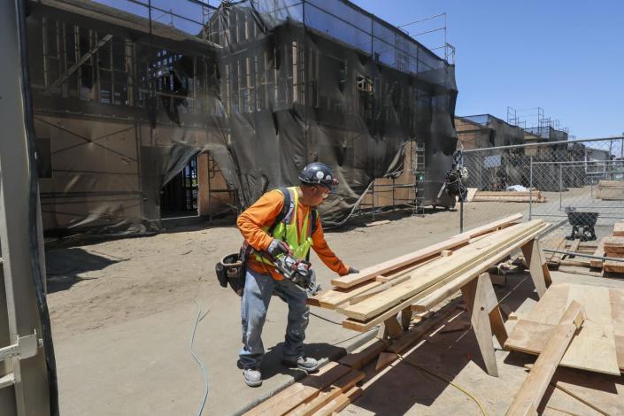 A worker cuts lumber for a low-income housing complex being rehabbed in San Francisco.