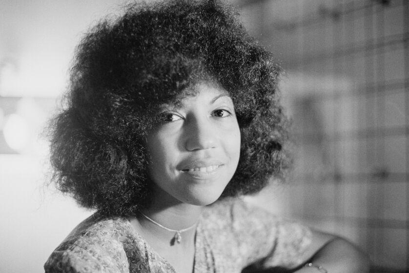 A black-and-white photo of Linda Lewis smiling in a floral shirt