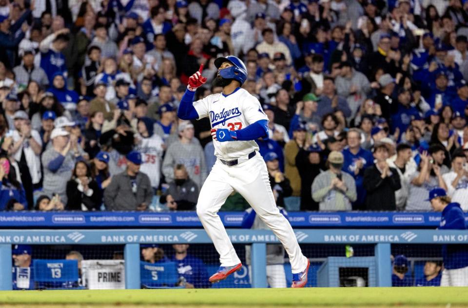 Teoscar Hernández points skyward after hitting a three-run home run off Giants relief pitcher Tyler Rogers.