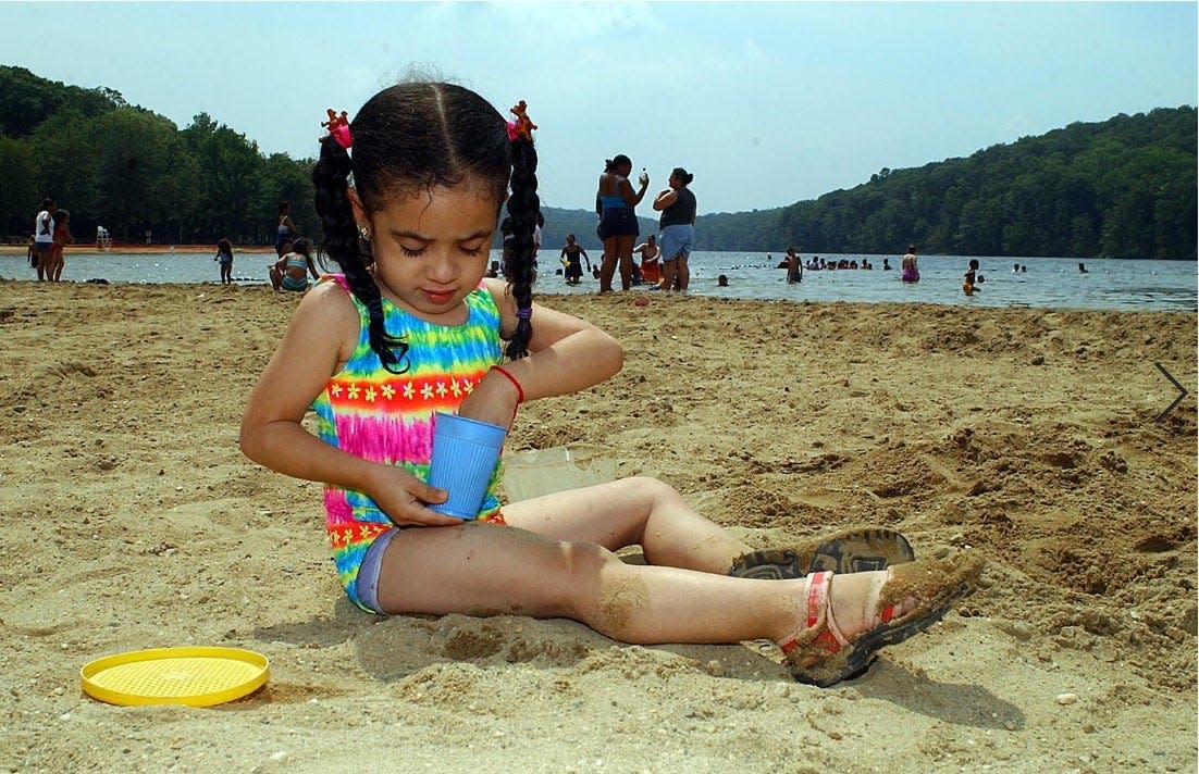 A girl plays in the sand at Sebago Beach in 2002. The beach closed to the public in 2011 after it was heavily damaged by Hurricane Irene. The beach at Lake Sebago, the biggest lake in Harriman State Park, is finally undergoing repairs and could open in 2027.