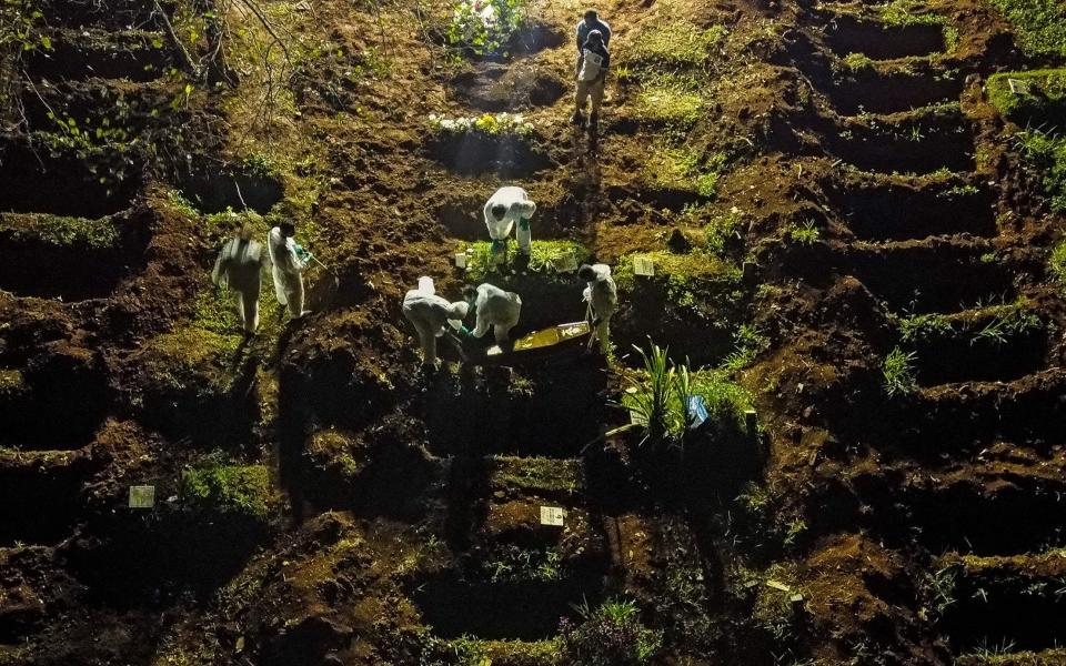 Aerial view showing a coffin being buried at the Vila Formosa cemetery in Sao Paulo, Brazil - AFP