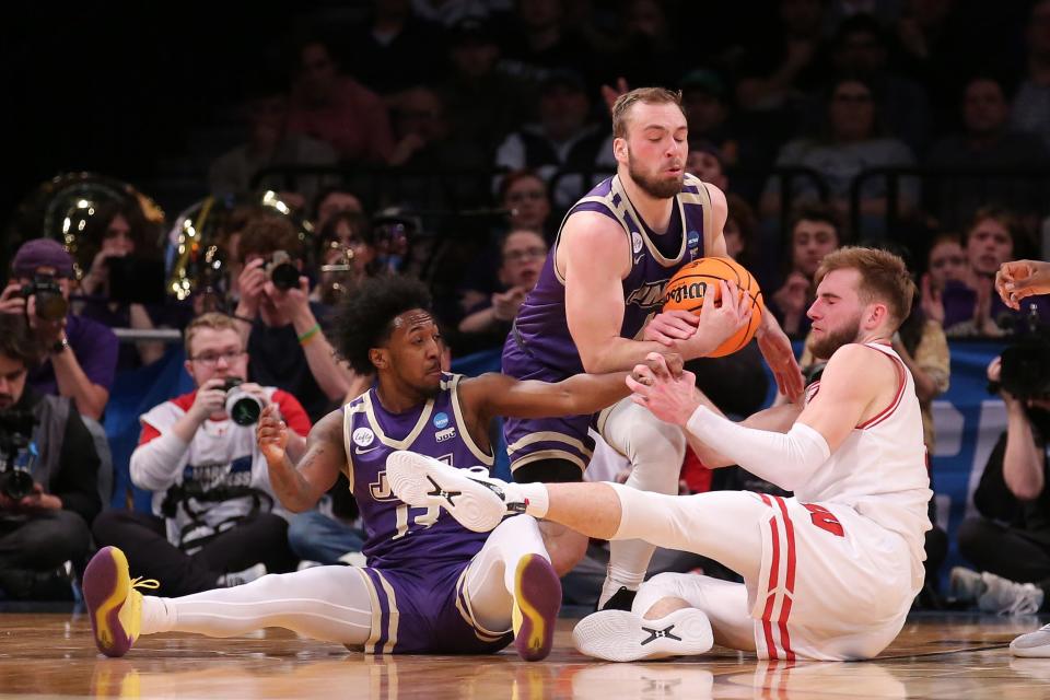 James Madison guard Noah Freidel (1) fights for a loose ball with Wisconsin forward Tyler Wahl (5) during the first round of the 2024 NCAA men's tournament at the Barclays Center.