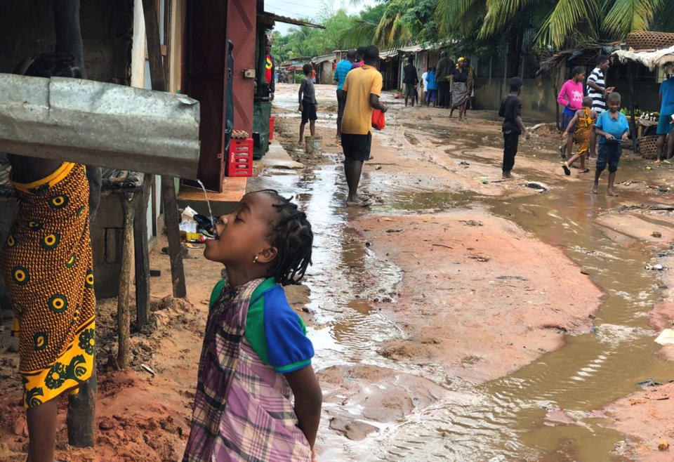 A child drinks water from a gutter during floods due to heavy rains in Pemba, Mozambique, Sunday, April 28, 2019. Serious flooding began on Sunday in parts of northern Mozambique that were hit by Cyclone Kenneth three days ago, with waters waist-high in areas, after the government urged many people to immediately seek higher ground. Hundreds of thousands of people were at risk. (AP Photo/Tsvangirayi Mukwazhi)