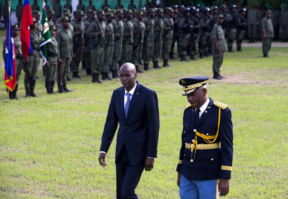 Haiti's President Jovenel Moise, left, reviews troops with Jodel Lesage, lieutenant-general of the Armed Forces, at the national palace during a ceremony marking the 216th anniversary of Battle of Vertieres in Port-au-Prince, Haiti, Monday, Nov. 18, 2019. The battle was the last major battle of Haitian independence from France. (AP Photo/Dieu Nalio Chery)