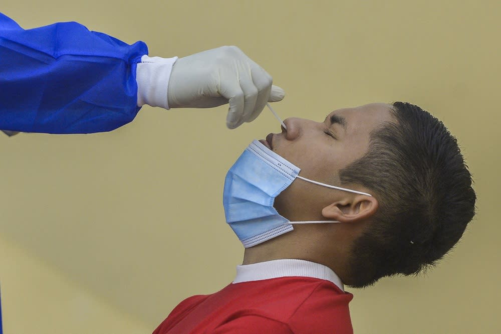 A health worker collects a swab sample from a man to test for Covid-19 in Petaling Jaya January 18, 2021. —  Picture by Miera Zulyana