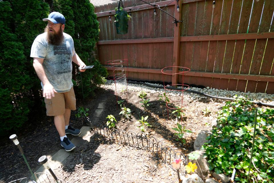 T.J. Kester describes the several unique hot pepper plants he has growing in the backyard of the home he shares with his partner, Paul Berens, in South Milwaukee.