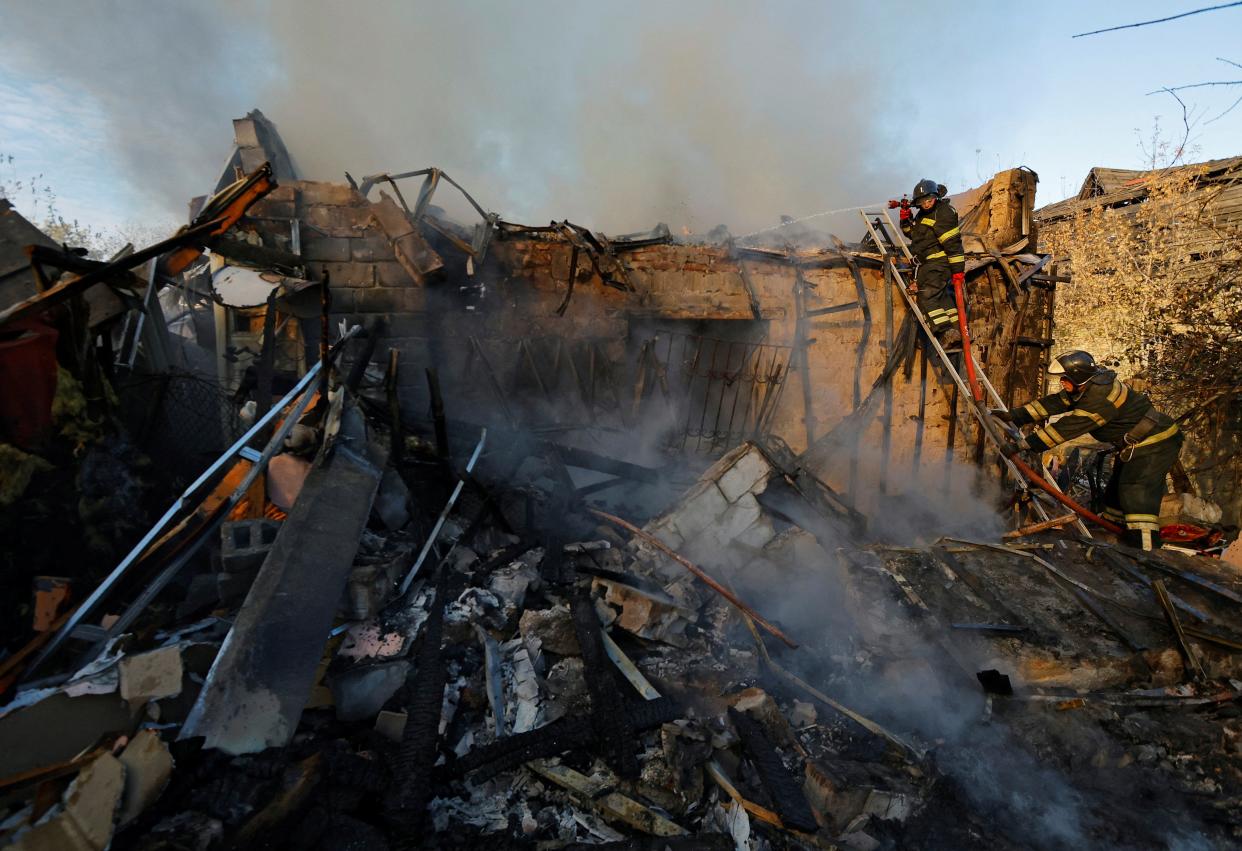 Firefighters work to put out fire at a house that was hit by shelling in Donetsk (REUTERS)