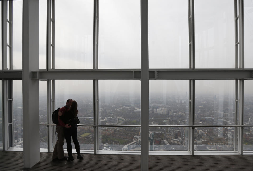 A couple kisses on the viewing platform of a skyscraper in central London, Thursday, April 3, 2014. British authorities have warned people with heart or lung conditions to avoid exertion as a combination of industrial pollution and Sahara dust blankets the country in smog. The environment department said air pollution level could reach the top rung on its 10-point scale. The pollution is expected to ease by Friday. (AP Photo/Lefteris Pitarakis)