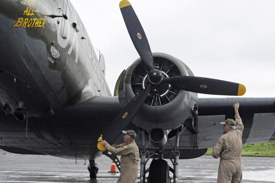 In this April 9, 2019, photo, Pilot Tom Travis, left, and crew member Ray Clausen turn a prop on the World War II troop carrier That's All, Brother during a stop in Birmingham, Ala. The World War II aircraft that took part in the D-Day invasion in 1944 is returning to Europe for the 75th anniversary of the battle. It could be the last great commemoration of the Allied battle to include D-Day veterans, many of whom are now in their 90s. (AP Photo/Jay Reeves)