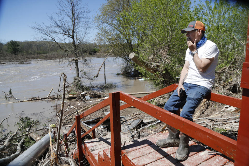 Dan Dionne looks over his former deck outside his home, Wednesday, May 20, 2020, in Edenville, Mich. Some people living along two mid-Michigan lakes and parts of a river have been evacuated following several days of heavy rain that produced flooding and put pressure on dams in the area returned to the area to survey the damage. (AP Photo/Carlos Osorio)