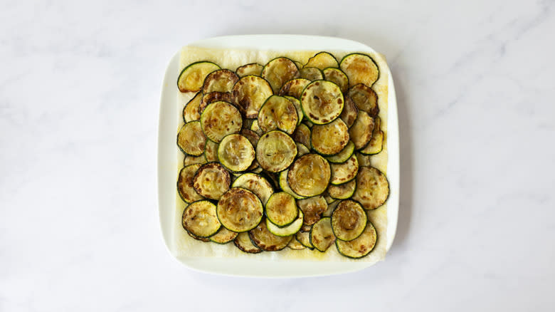 fried zucchini slices on paper towel 