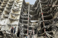 In this photo provided by Tasnim News Agency, debris hangs from the Metropol buildin,g a 10-story commercial building under construction, in the southwestern city of Abadan, Iran, Tuesday, May 24, 2022. Rescuers dug through debris Tuesday of the collapsed building that killed at least 11 people, fearful that many more could still be trapped beneath the rubble as authorities arrested the city's mayor in a widening probe of the disaster. (Hossein Abdollah Asl, Tasnim News Agency via AP)