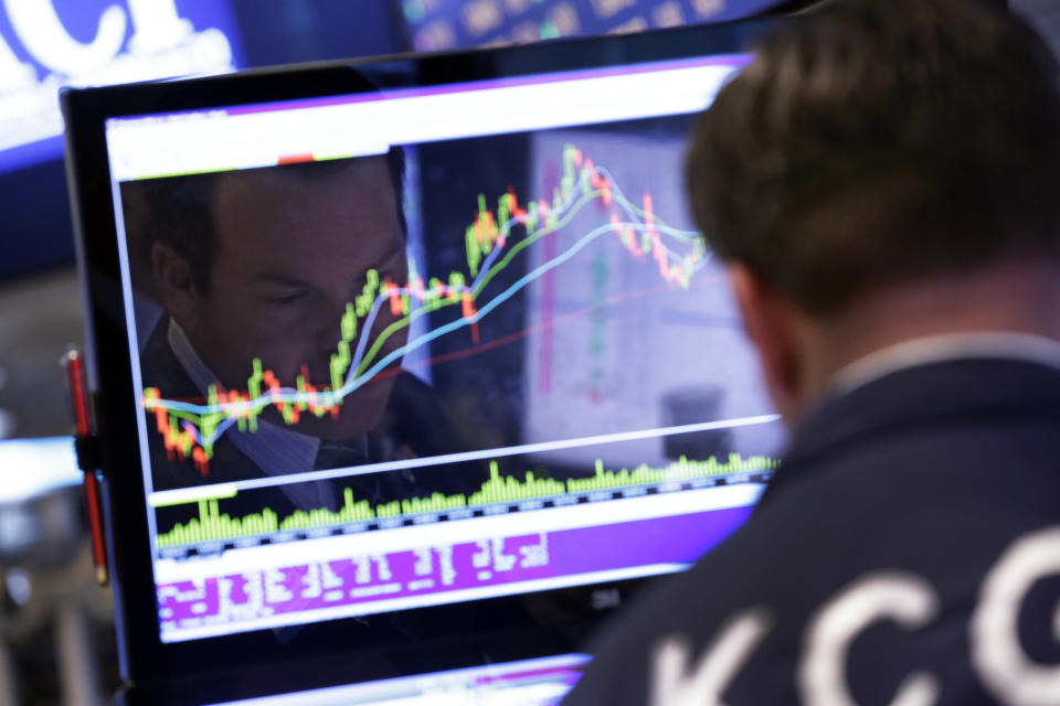 FILE - In this April 28, 2014 file photo, specialist Charles Boeddinghaus is reflected in one of his screens, at his post on the floor of the New York Stock Exchange. The most widely used benchmark for investment funds, the Standard & Poor's 500 index, is up 104 percent since Ben Bernanke outlined QE2 in August 2010, powered by a stronger economy, higher spending and record corporate profits. (AP Photo/Richard Drew, File)