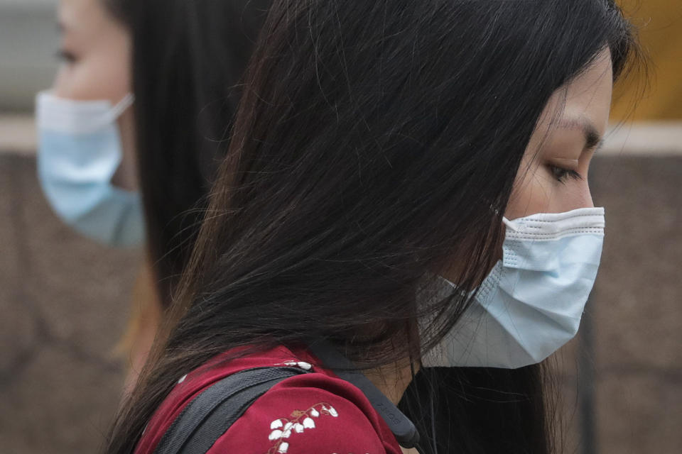 Women wearing face masks to protect against the new coronavirus walk past each other on a street in Beijing, Tuesday, July 28, 2020. New coronavirus cases continue to rise in China's northwestern region of Xinjiang, with more than dozens reported on Tuesday. The capital Beijing also reported its first case of domestic transmission in more than two weeks, while the northeastern province of Liaoning added another several cases in its local outbreak. (AP Photo/Andy Wong)