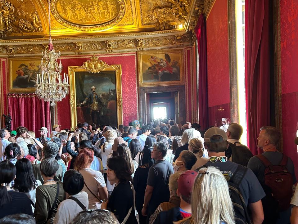 Touristen stehen in einem Raum des Schlosses von Versailles. - Copyright: Jordan Parker Erb/Insider