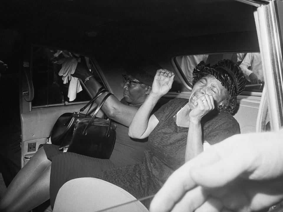 Anna Powell, mother of James Powell, crying in the back of a police car.