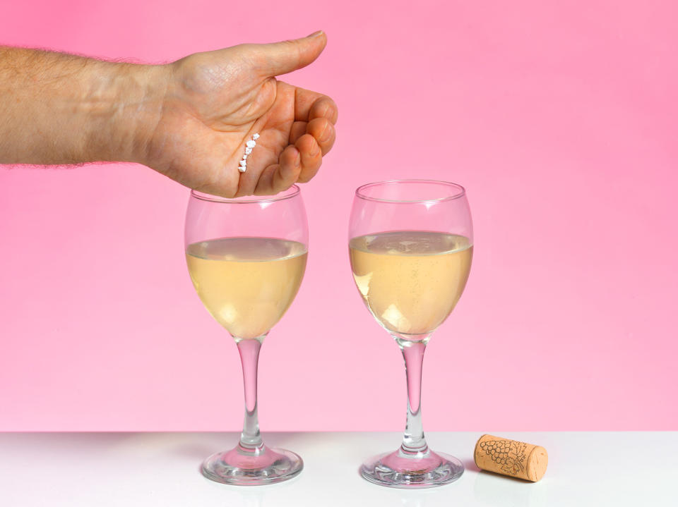 A stock image of someone demonstrating dropping a drug into a drink