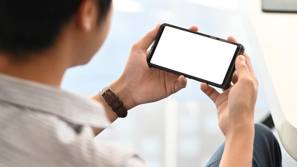 A man looking at his phone screen.