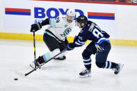 Winnipeg Jets' Kyle Connor (81) skates past Seattle Kraken's Jamie Oleksiak (24) during the third period of an NHL hockey game in Winnipeg, Manitoba on Tuesday April 16, 2024. (Fred Greenslade/The Canadian Press via AP)