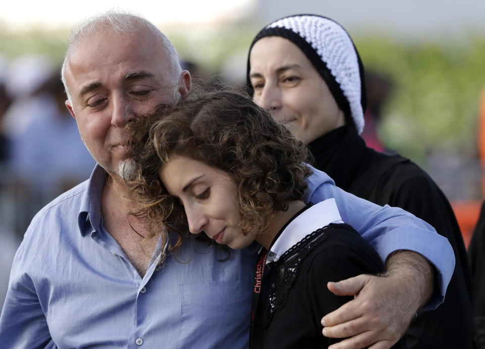 Mourners embrace following a burial ceremony at Memorial Park Cemetery in Christchurch, New Zealand, Friday, March 22, 2019. Funerals continued following the Friday, March 15 mosque attacks where 50 worshippers were killed by a white supremacist. (AP Photo/Mark Baker)