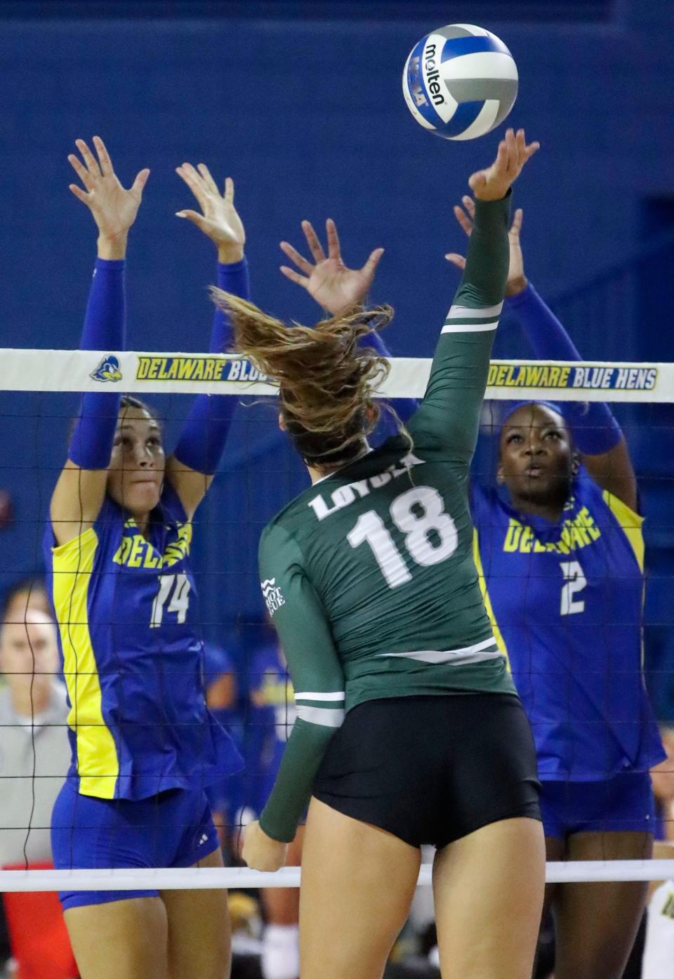 Delaware's Kirah Johnson (left) and Lani Mason leap to attempt to block Loyola's Kennedy Stevens in the Blue Hens' 3-1 win against Loyola (Md.) in the season-opening Blue Hen Invitational at the Bob Carpenter Center, Friday, August 25, 2023.