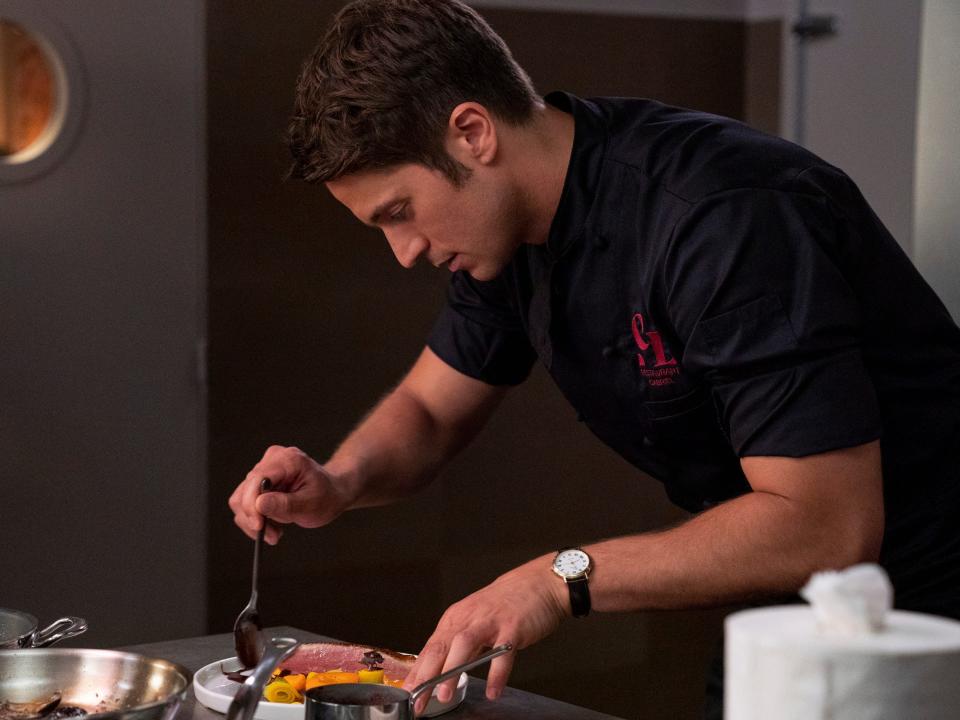 gabriel preparing a plate in his restaurant on season 2 of emily in paris