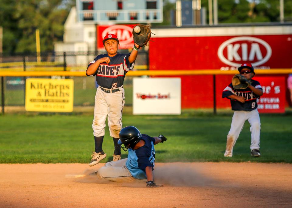 Shortstop Joel Vasquez of Dave's leaps to receive the throw from his catcher as Yaniel Fernandes of TS Sports slides safely into second base in recent action at Whaling City Youth Baseball.