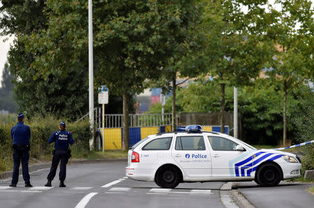 Belgian police officers secure a road near the Belgium's National Institute of Criminology after arsonists set fire to it in Brussels, Belgium August 29, 2016. REUTERS/Eric Vidal