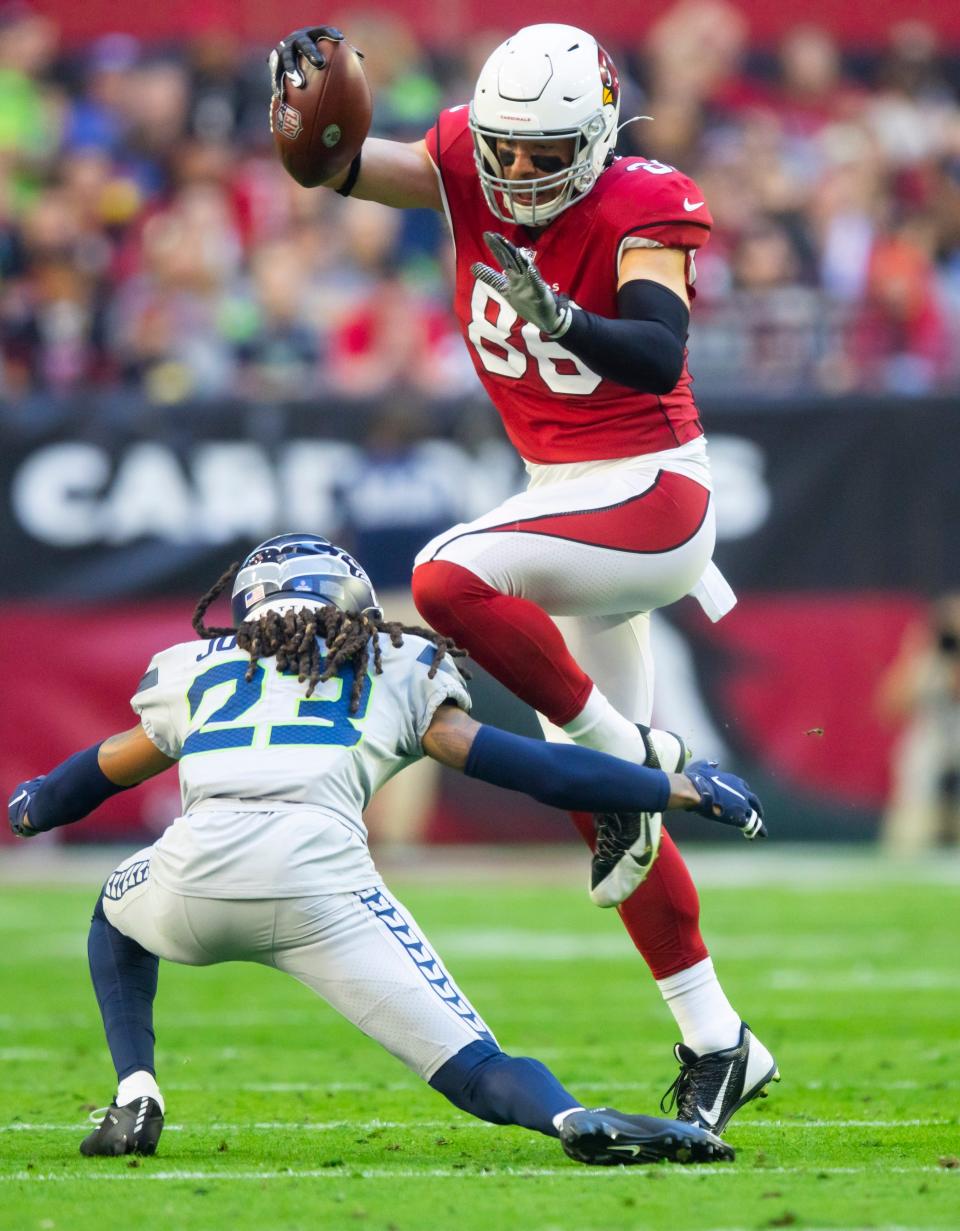 Arizona Cardinals tight end Zach Ertz hurdles Seattle Seahawks cornerback Sidney Jones IV.