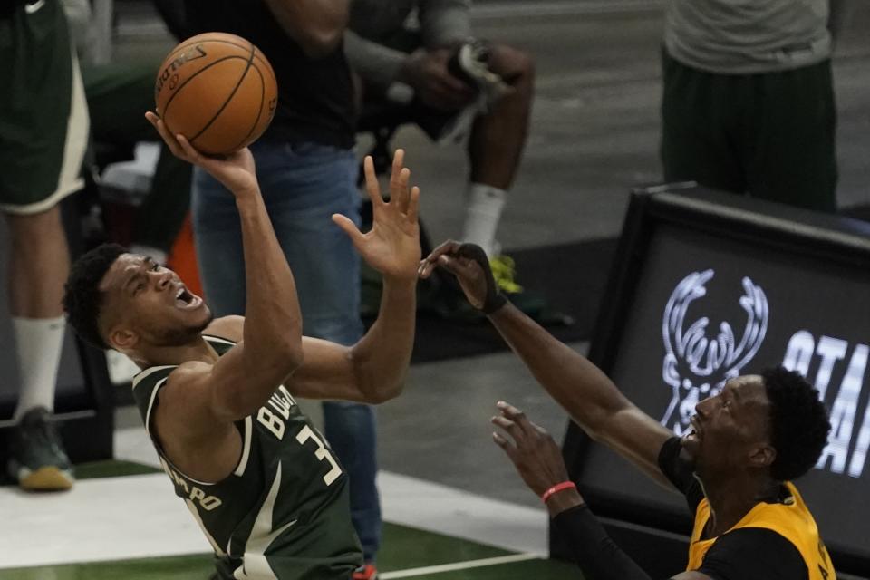 Milwaukee Bucks' Giannis Antetokounmpo shoots over Miami Heat's Bam Adebayo during the first half of Game 1 of their NBA basketball first-round playoff series Saturday, May 22, 2021, in Milwaukee. (AP Photo/Morry Gash)