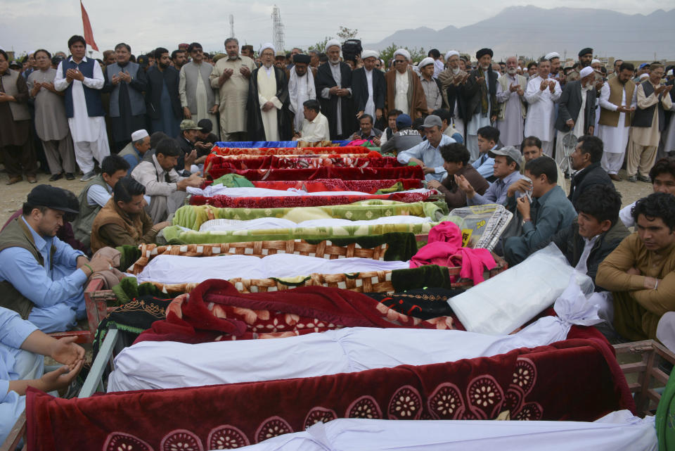 FILE - In this April 12, 2019 file photo, people offer prayers and wait to bury the bombing victims at a funeral in Quetta, Pakistan. Pakistan has gone from thousands of terrorist attacks a year to a record low of less than 250 last year, according to two separate Pakistan-based organizations tracking militant activity. (AP Photo/Arshad Butt,file)